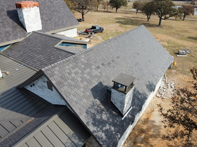 Aerial view of a composite shake roof with standing seam metal sections, installed by Snow Roofing & Exteriors