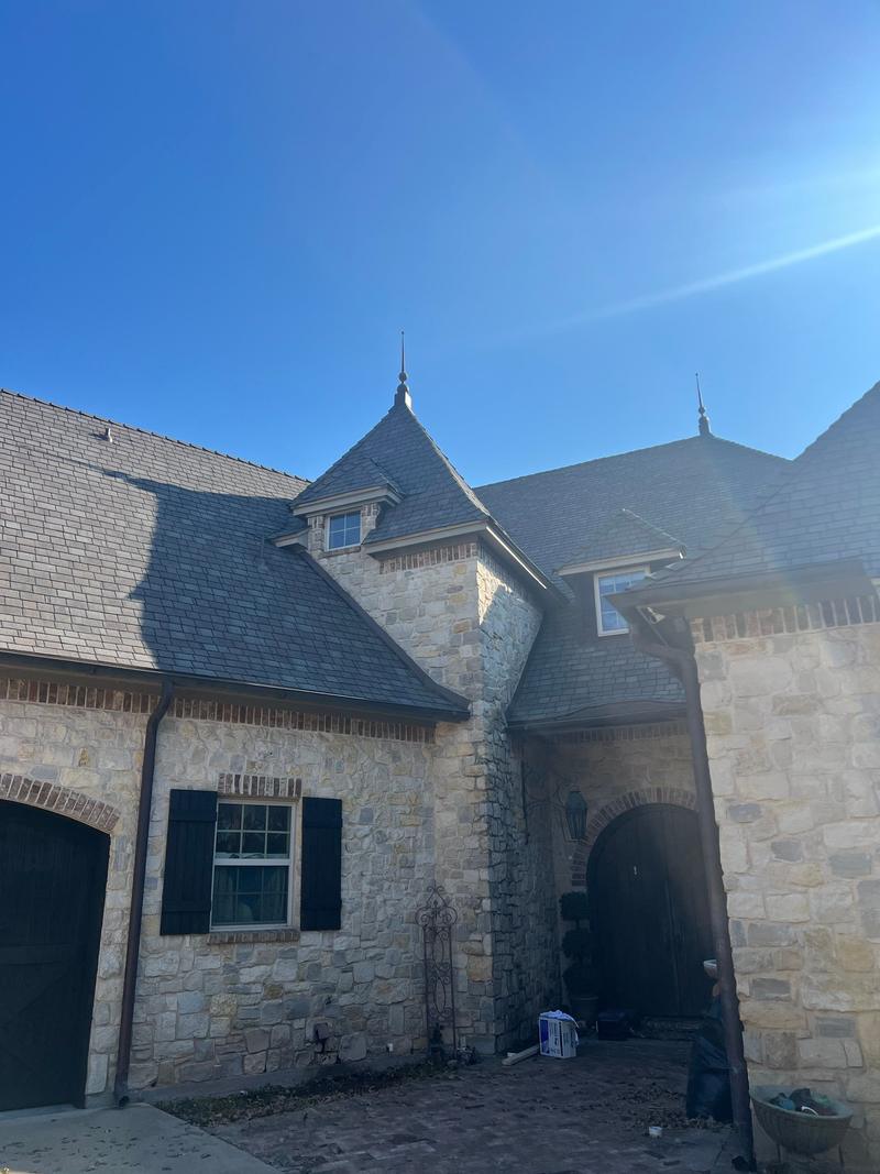 Slate-look designer shingle roof with a turret on a stone French-country home near Bridgeport, TX