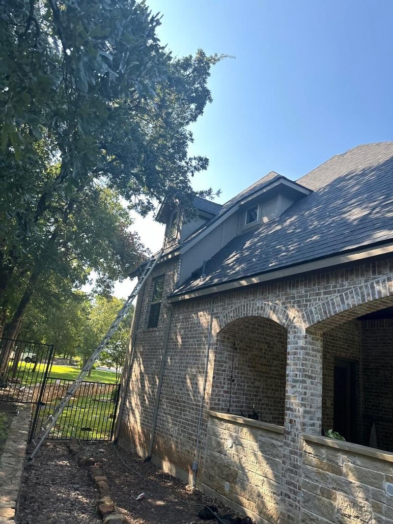 Shingle roof above an arched brick loggia on a large North Texas home